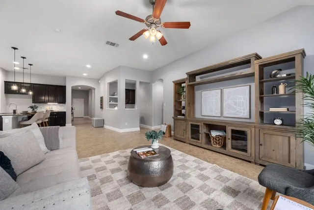 a living room with furniture a flat screen tv and a fireplace
