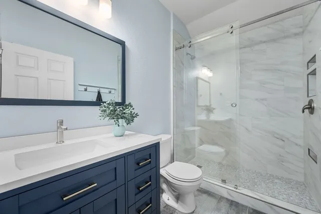 a bathroom with a sink a toilet and shower