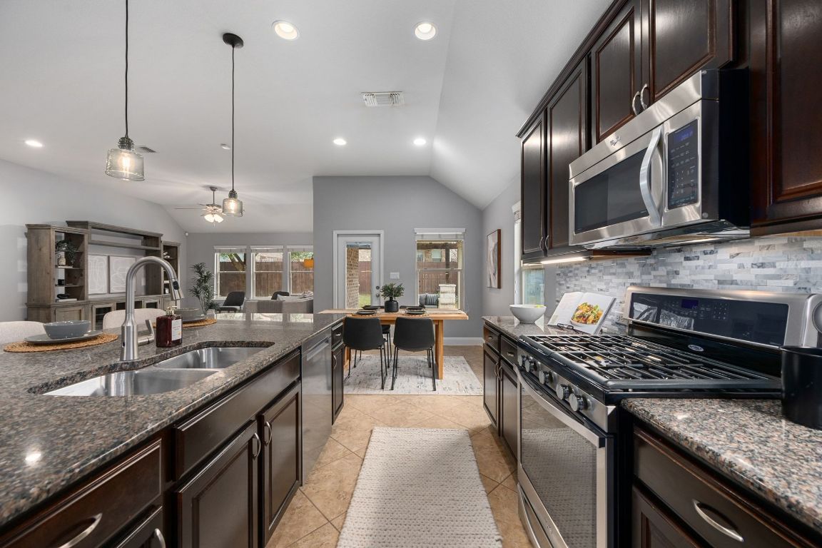 2041 Elaina Loop Leander, TX 78641 - Photo 2 of 25 The eat-in kitchen features an oversized center island, granite countertops, SS appliances and under-cabinet lighting.