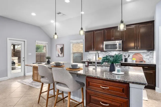 a kitchen with sink a microwave and wooden cabinets