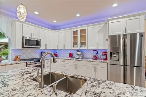 a kitchen with stainless steel appliances a sink microwave and refrigerator