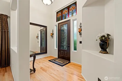 a view of a hallway with wooden floor and living room