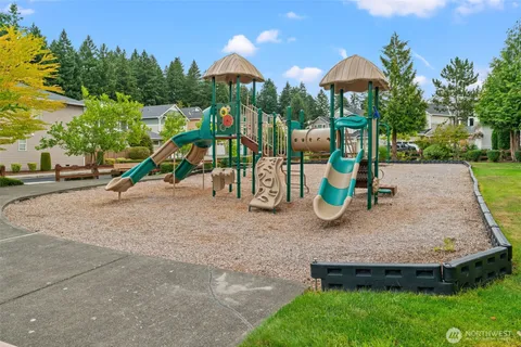 a childrens park with lots of swings slides and slide