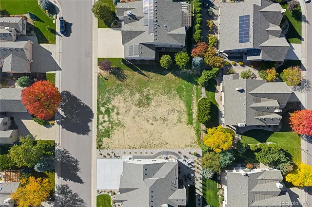 an aerial view of a house with a yard and large trees
