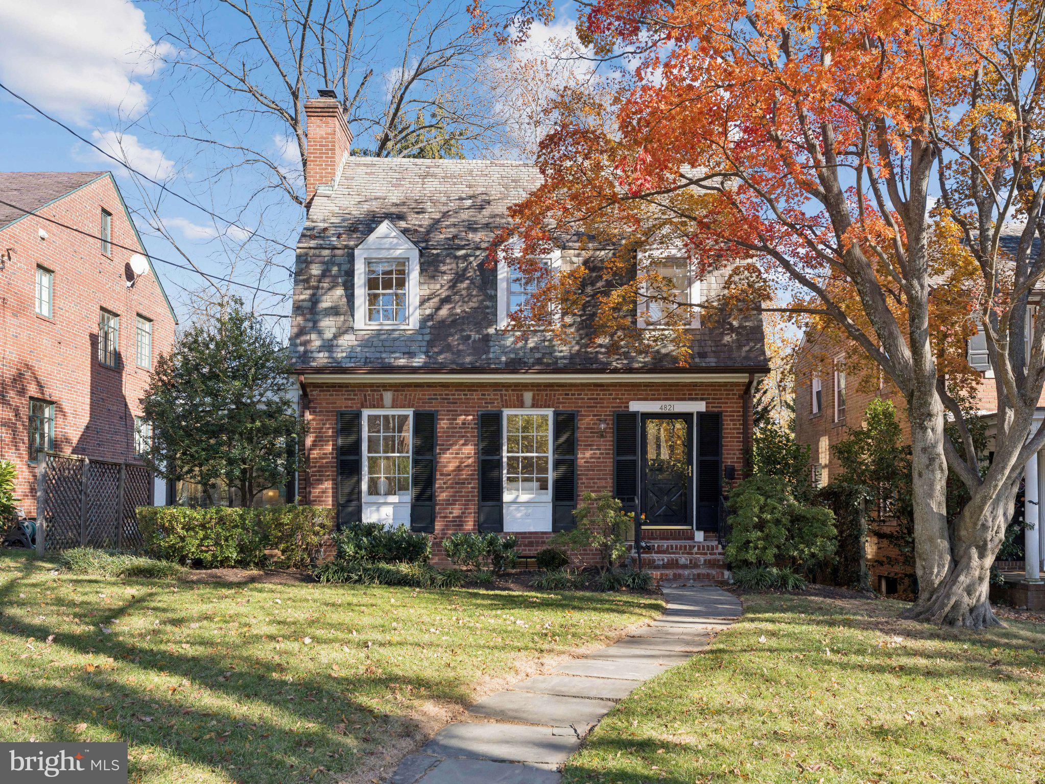 a view of a brick house with a large windows and a large tree