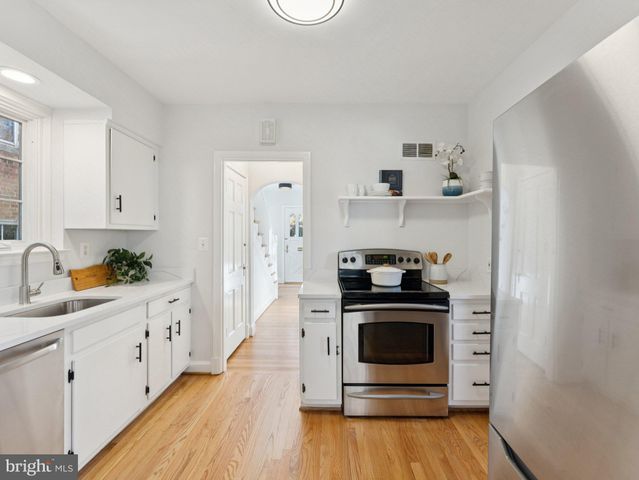 a kitchen with a stove and white cabinets