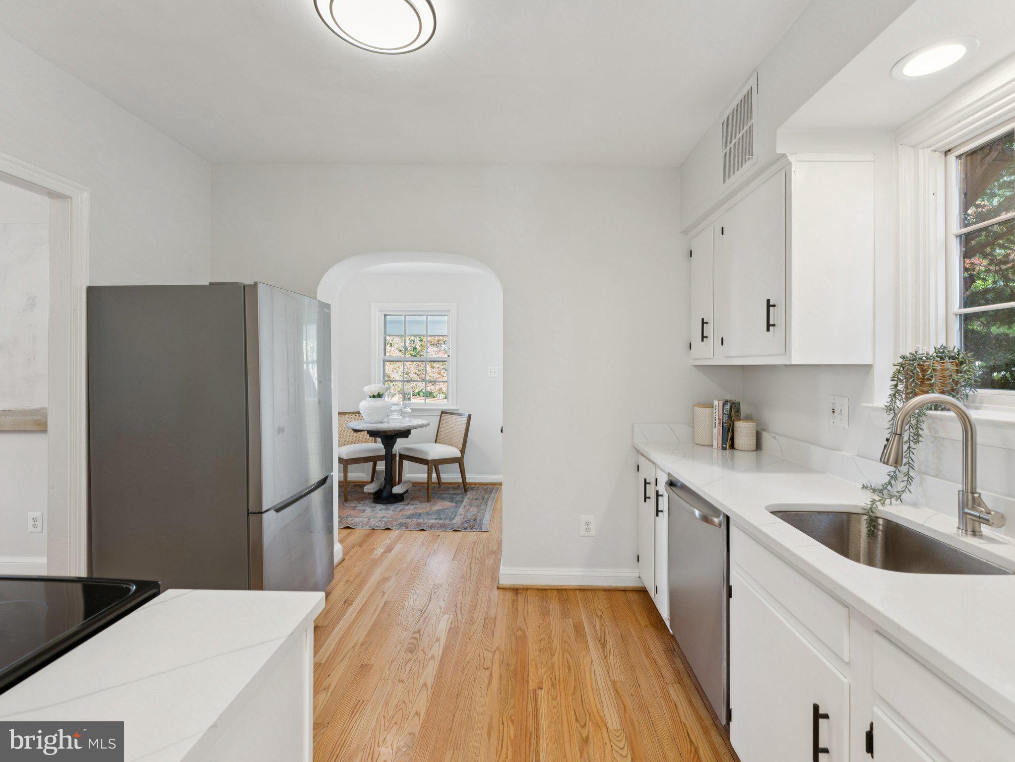 4821 45th Street Northwest Washington, DC 20016 - Photo 15 of 38 a kitchen with a sink a refrigerator and wooden floor
