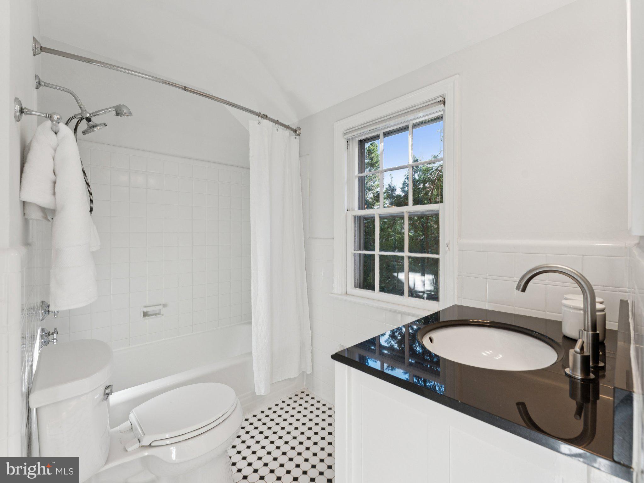 4821 45th Street Northwest Washington, DC 20016 - Photo 27 of 38 a bathroom with a granite countertop sink toilet a mirror and shower