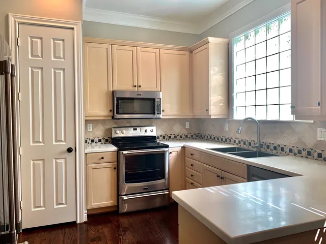a kitchen with stainless steel appliances granite countertop a stove a sink and a microwave