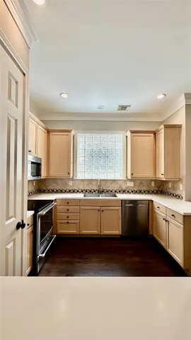 a large kitchen with kitchen island granite countertop a stove a sink a refrigerator and white cabinets