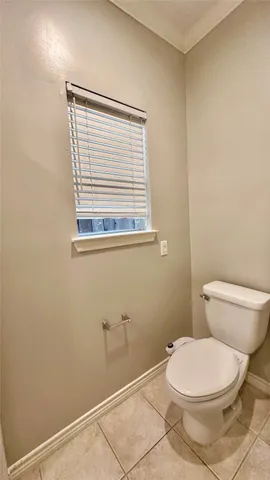 a white toilet sitting next to a window