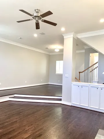 a view of an empty room with window and wooden floor