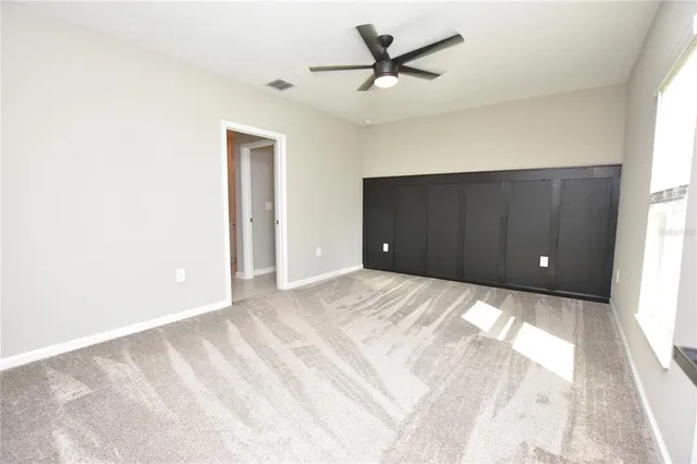 a view of a livingroom with a ceiling fan and window