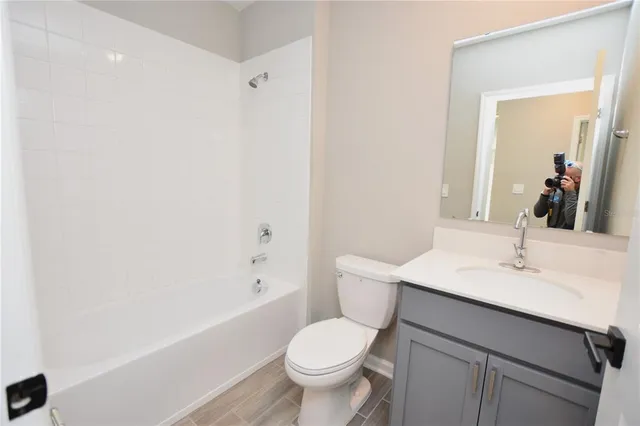 a bathroom with a sink toilet vanity and tub