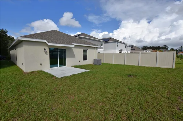 a view of a yard in front of a house with a large tree