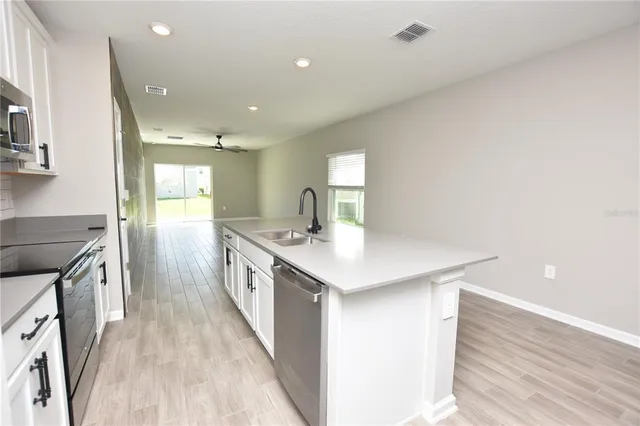 a large kitchen with a stove and a sink