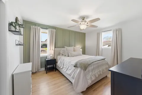 a bedroom with a bed ceiling fan and a window