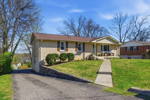 a front view of a house with yard and green space