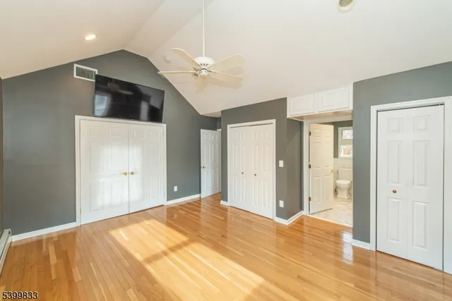 a bathroom with a granite countertop sink a toilet a large mirror and shower