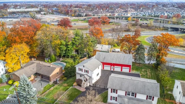 an aerial view of a house with swimming pool and large trees