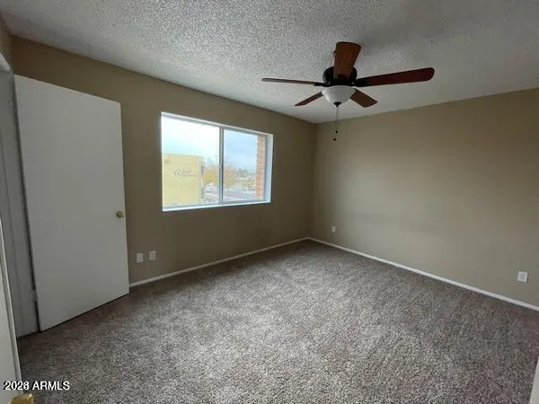 an empty room with windows and fan