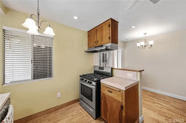 a kitchen that has a stove and a wooden floor