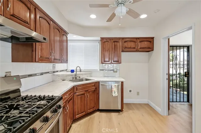 a kitchen with stainless steel appliances a sink stove and cabinets