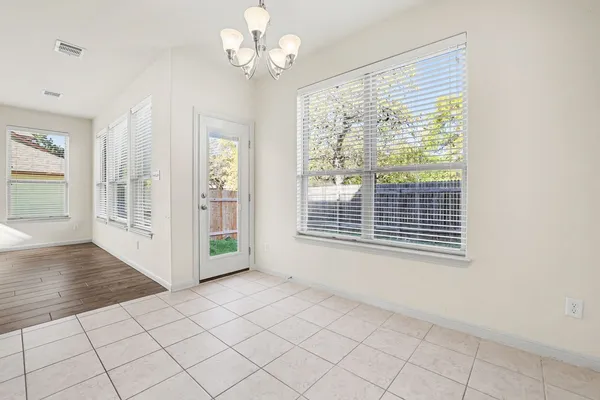 an empty room with chandelier and windows