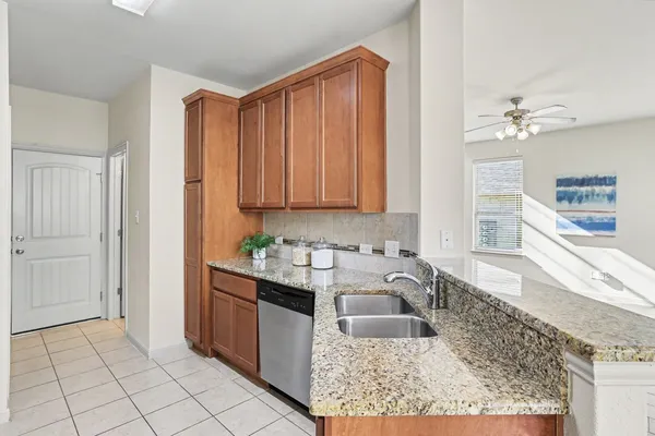 a kitchen with stainless steel appliances granite countertop a sink and a white cabinets