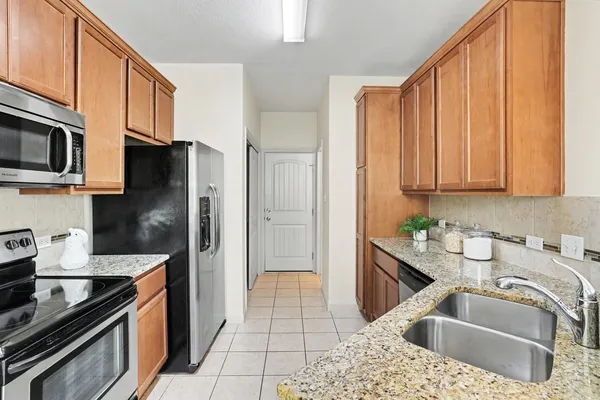 a kitchen with stainless steel appliances granite countertop a sink stove and refrigerator