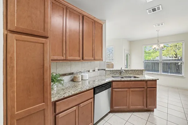 a kitchen with stainless steel appliances granite countertop cabinets and window