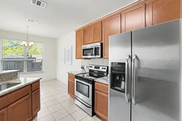 a kitchen with stainless steel appliances granite countertop a refrigerator stove and sink