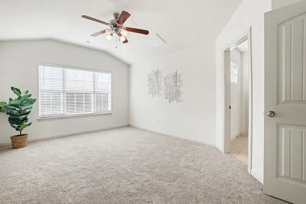 an empty room with windows and ceiling fan