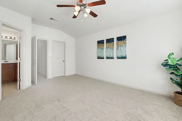 an empty room with windows and chandelier fan