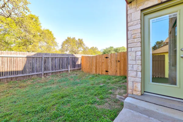 a view of a backyard with wooden fence
