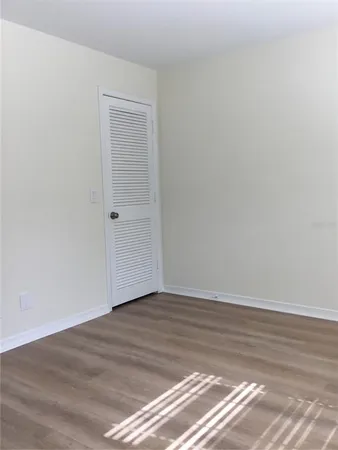 a view of a room with wooden floor and white walls