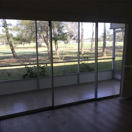 a view of empty room with wooden floor and floor to ceiling window