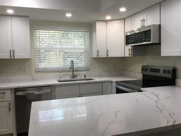 a kitchen with stainless steel appliances wooden cabinets a sink and a stove