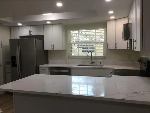 a kitchen with stainless steel appliances a sink stove and refrigerator