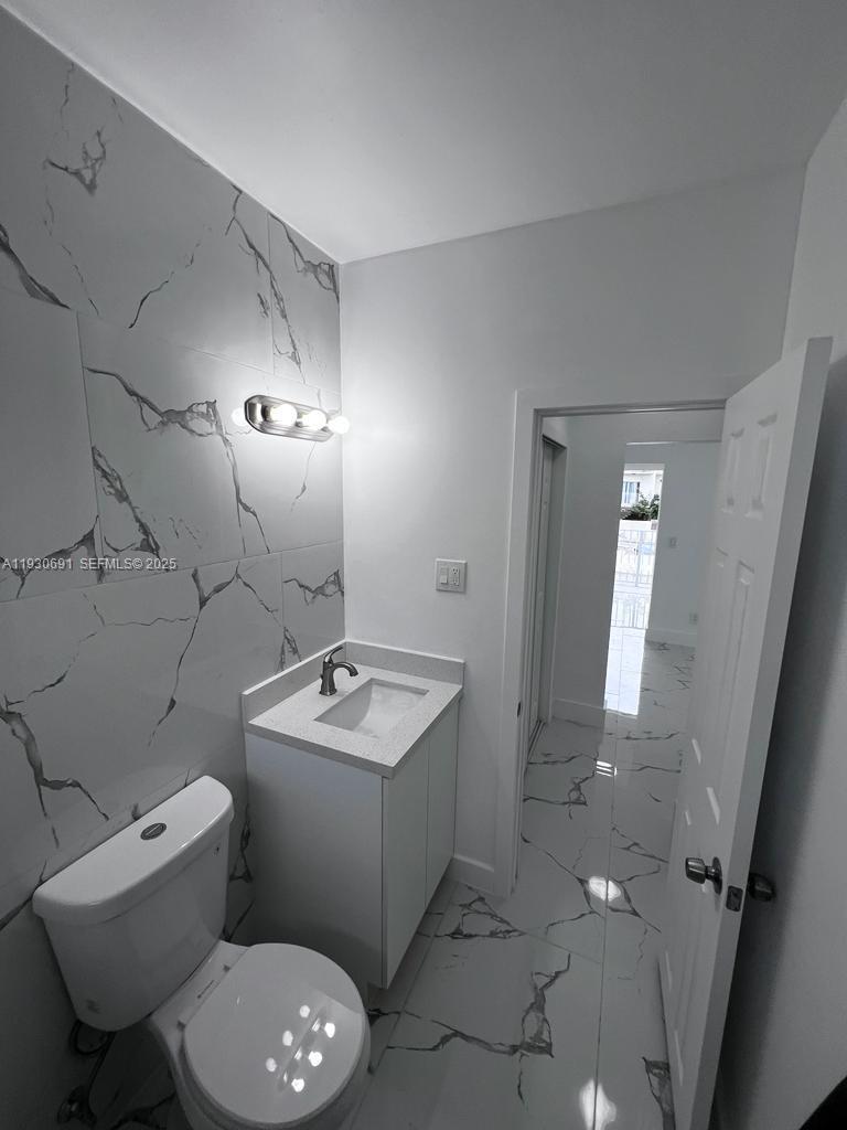 1131 Southwest 7th Street, Unit 3 Miami, FL 33130 - Photo 7 of 7 a bathroom with a toilet sink and mirror