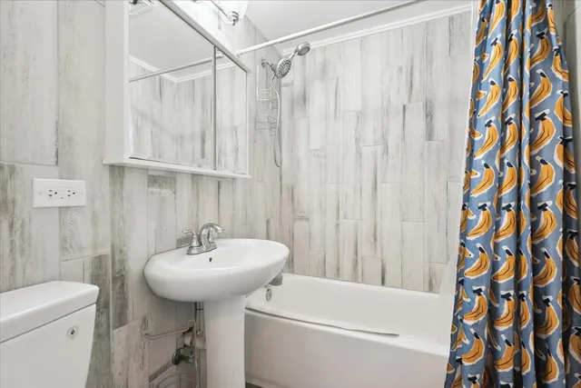 a bathroom with a sink a toilet and shower curtain