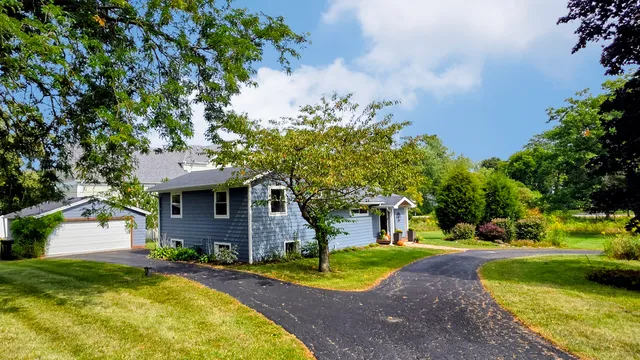 a front view of a house with a yard and trees