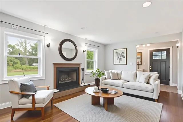 a living room with furniture a fireplace and a large window