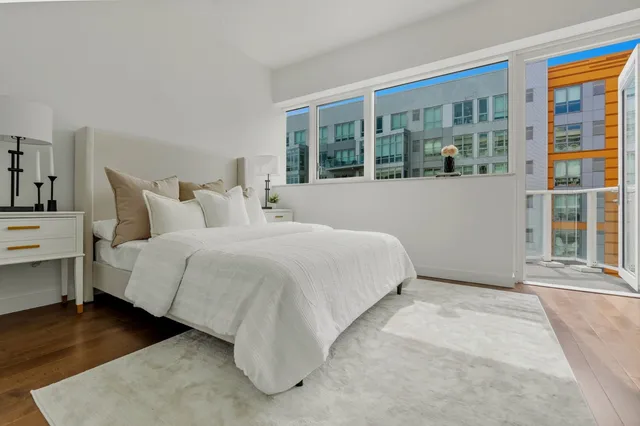 a bedroom with a bed and a large window