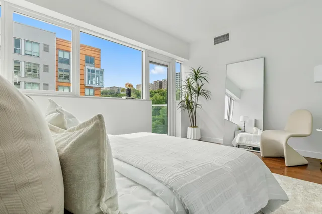 a bedroom with furniture and a large window