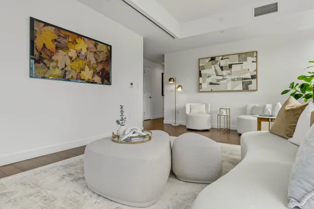 a living room with furniture and wall paintings