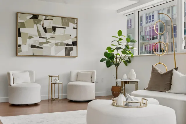a living room with furniture flowerpot and wooden floor