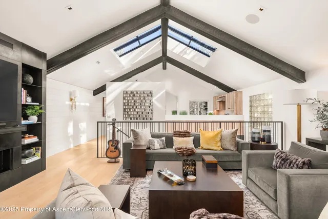 a living room with furniture kitchen view and a large window