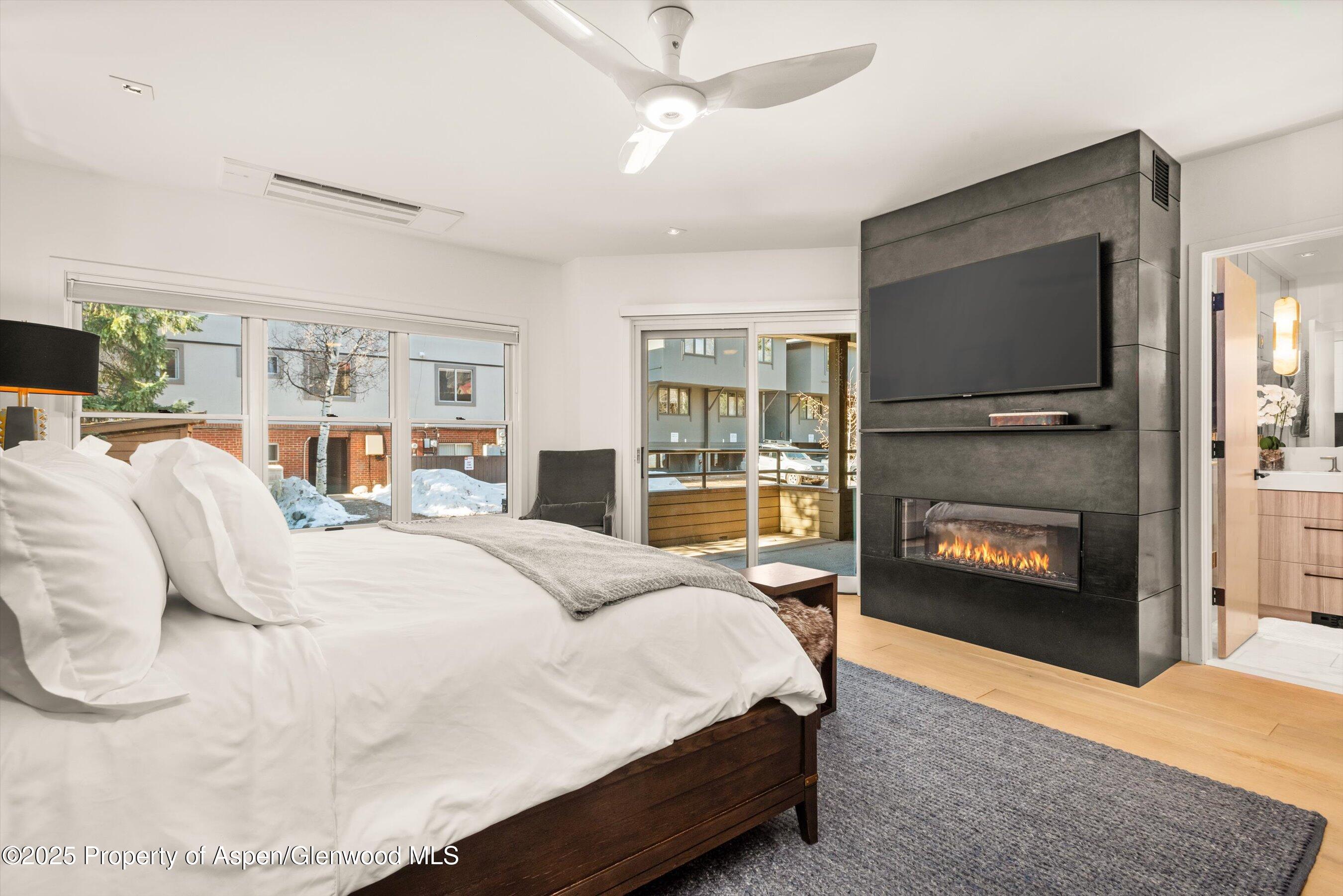 929 East Durant Avenue, Unit 4 Aspen, CO 81611 - Photo 24 of 43 a spacious bedroom with a bed and a fireplace