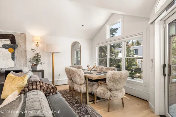a dining room with furniture a rug and a large window